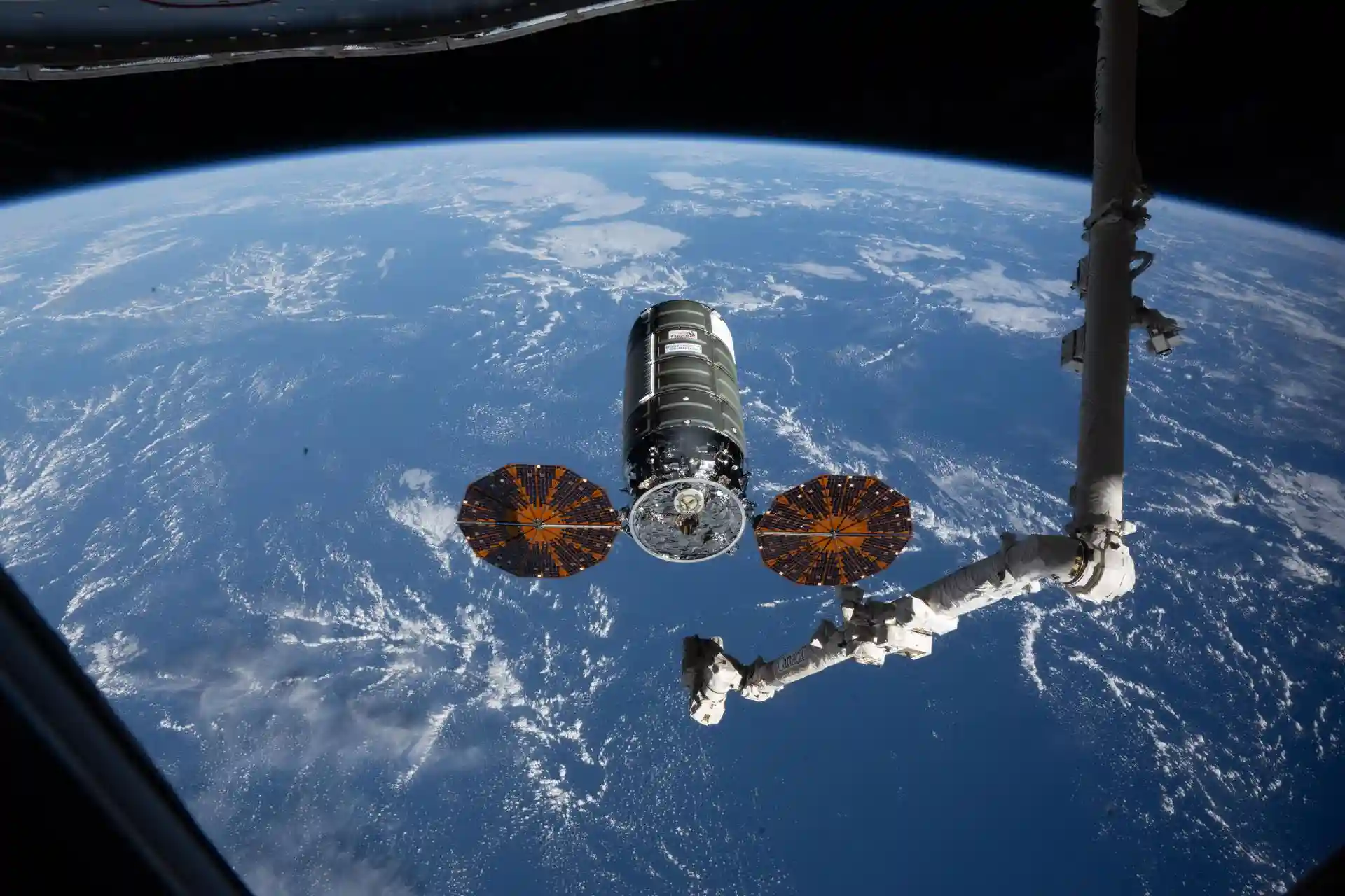 Cygnus XL cargo spacecraft and Canadarm2 above Earth on April 13, 2026
