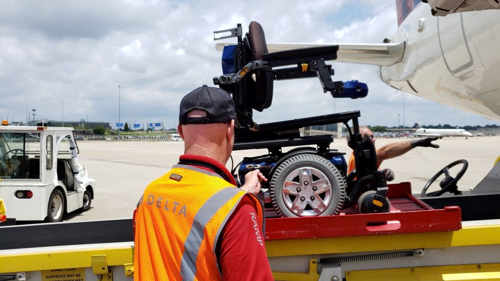 Delta ramp agent loading a wheelchair onto an aircraft